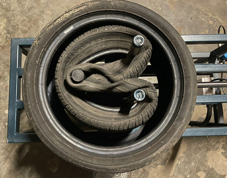 Placing another tyre on the machine – A larger tyre is put over the clamped tyre so that the clamped tyre is completely inside the larger tyre. 